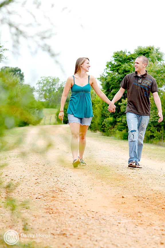 Engaged couple walking down dirt road | Davey Morgan Photography