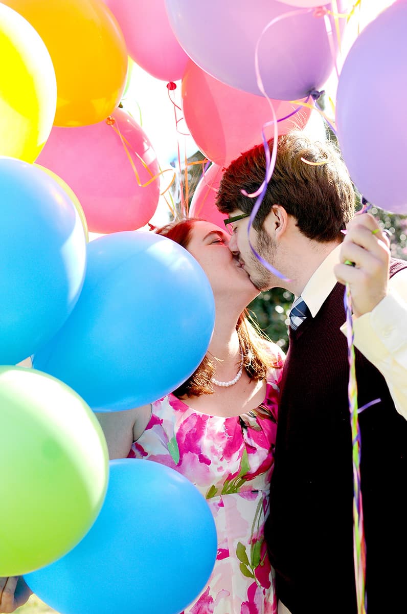 Pixar UP themed engagement pictures kissing in balloons in a park